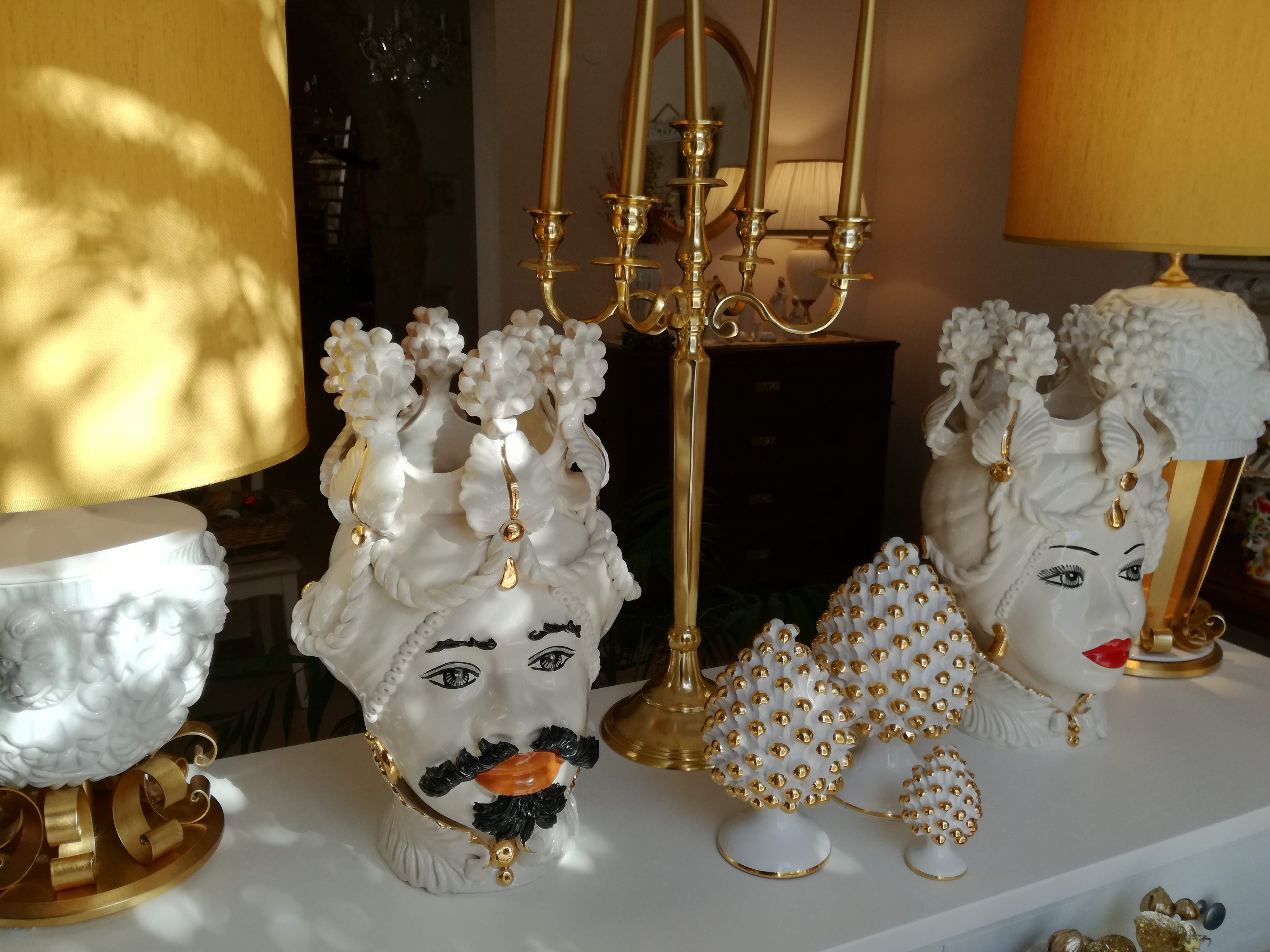 Pair of cream and pure gold Moor's heads with pine cones